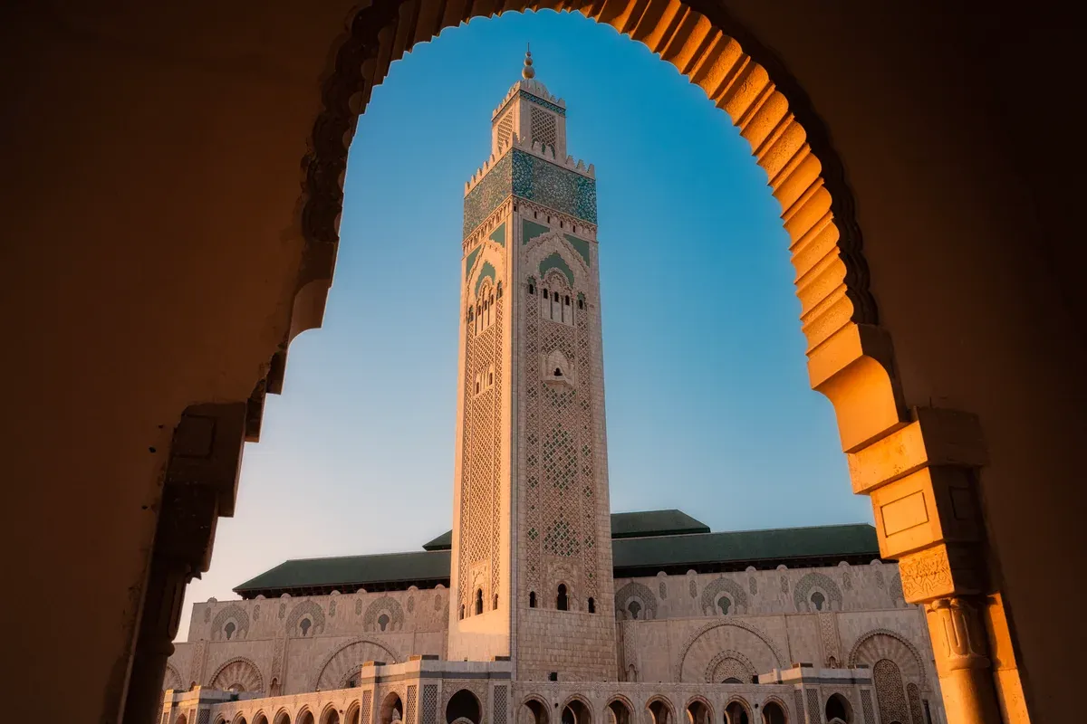 The minaret of the Hassan II Mosque in Casablanca seen through an arch on a Morocco tour package, Hassan II Mosque, Casablanca, Morocco