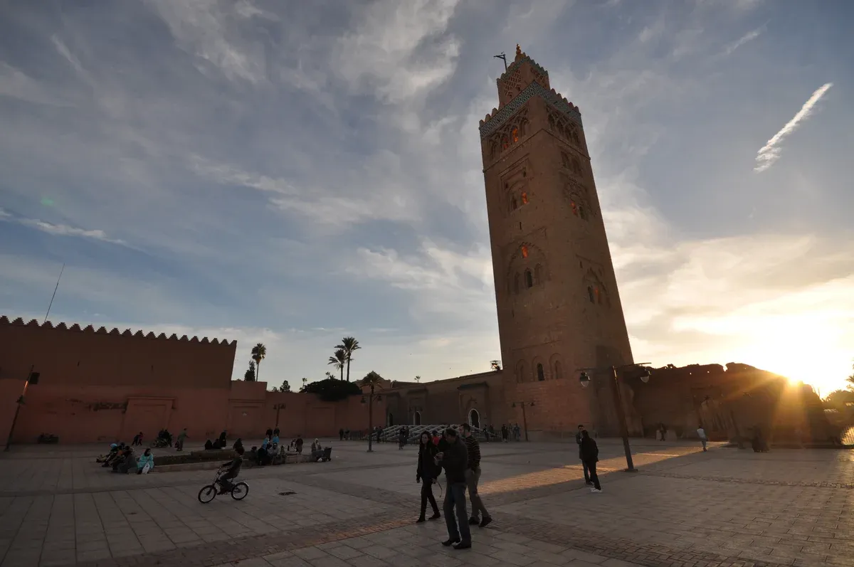 The Koutoubia minaret rising over the walls of Marrakech at sunset on a Morocco tour package, Koutoubia Mosque, Marrakech, Morocco